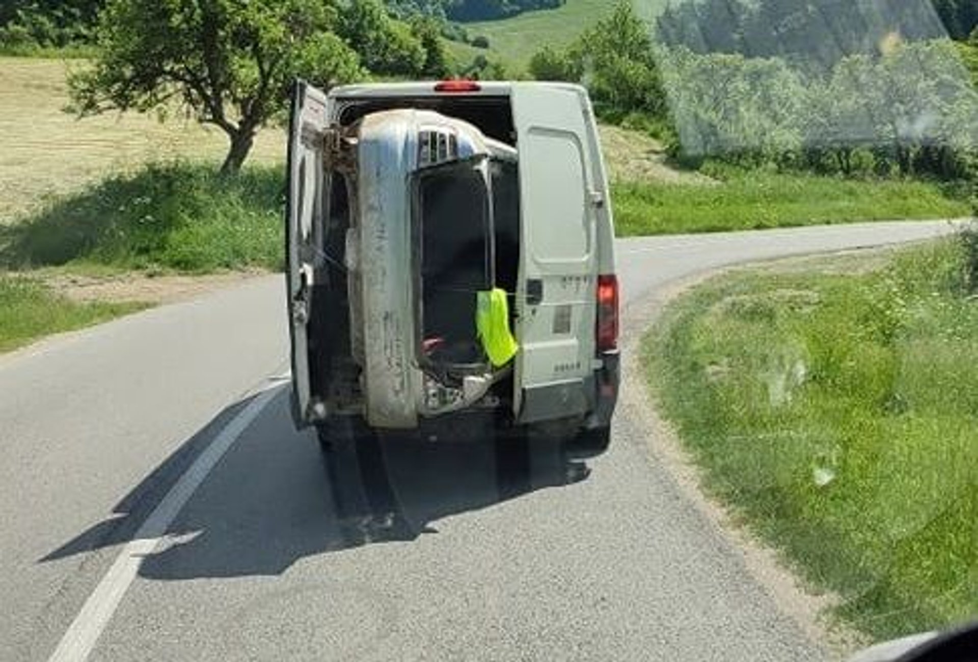 Kierowca wiózł samochód na pace dostawczaka.