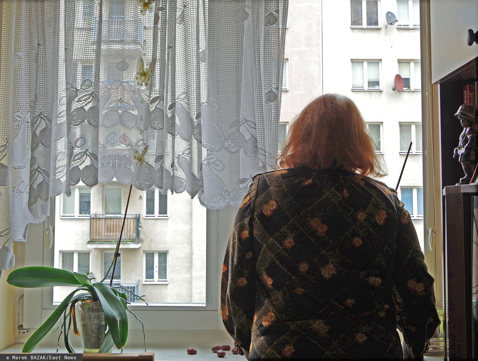 Kobieta stojąca w oknie 
