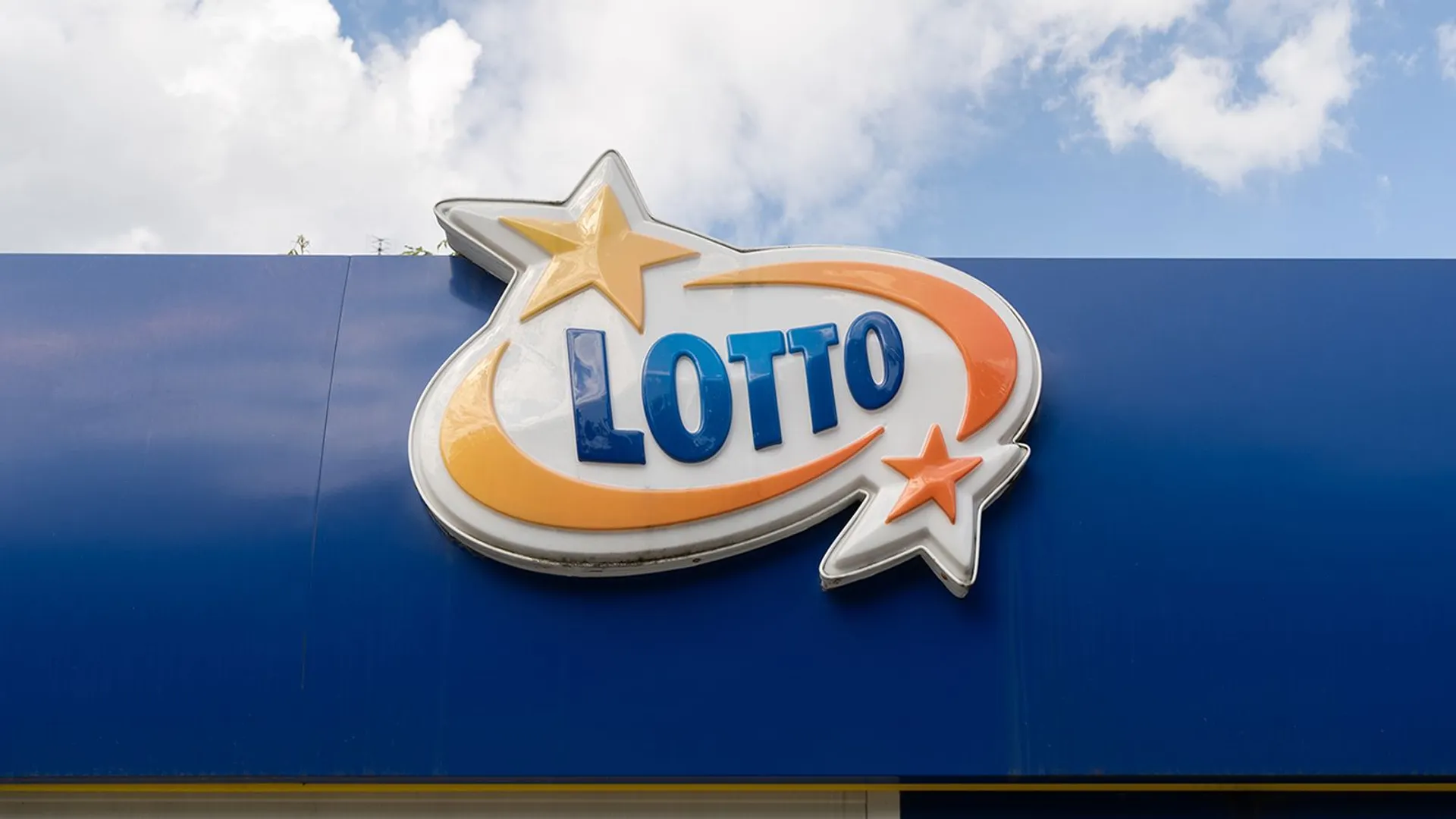 Szyld z logo marki Lotto. Tablica z logotypem polskiej loterii narodowej organizowanej przez Totalizator Sportowy.