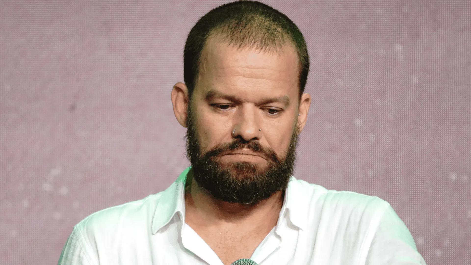 Michał Piróg w białej koszuli ze smutną miną