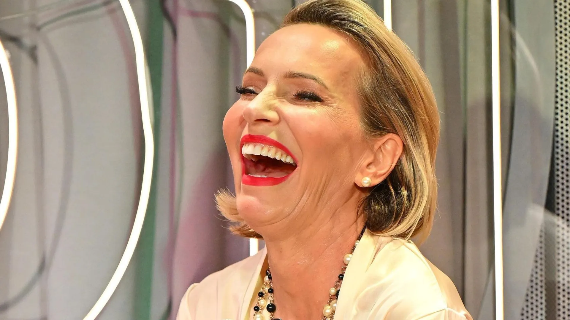 Paulina Smaszcz w czerwonej szmince szeroko się śmieje