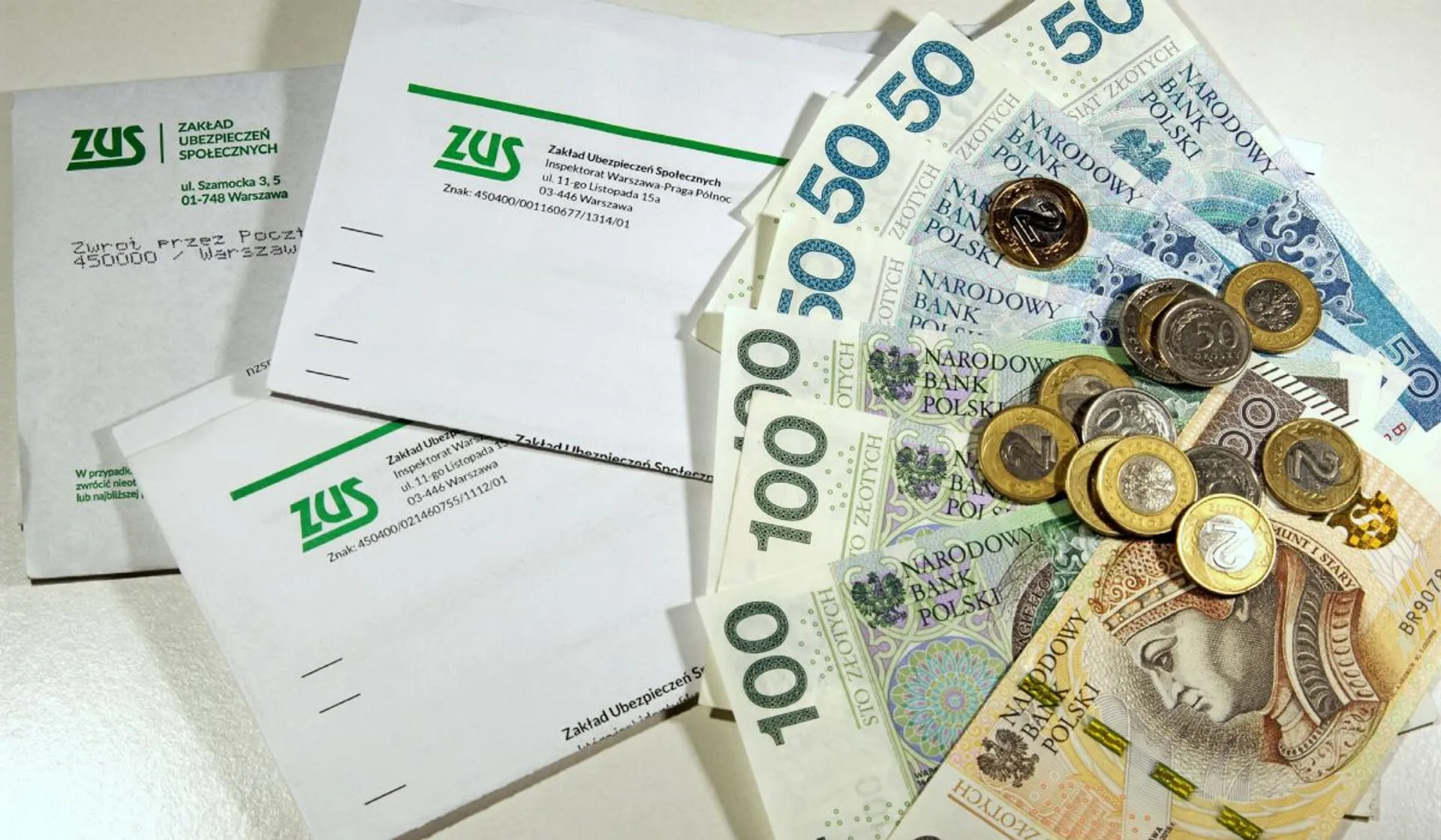 Koperty z logo ZUS-u, pieniądze