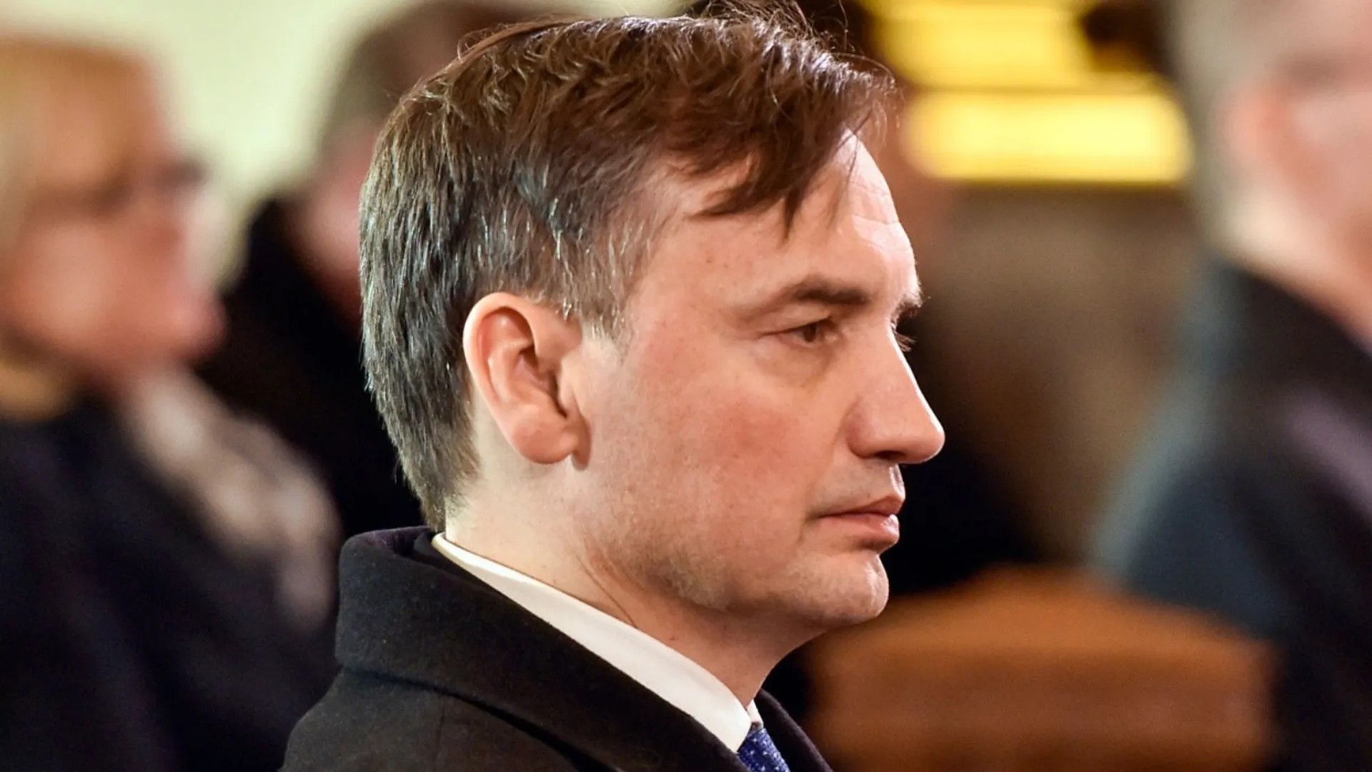 Zbigniew Ziobro podczas przemówienia, w ramce polski paszport.