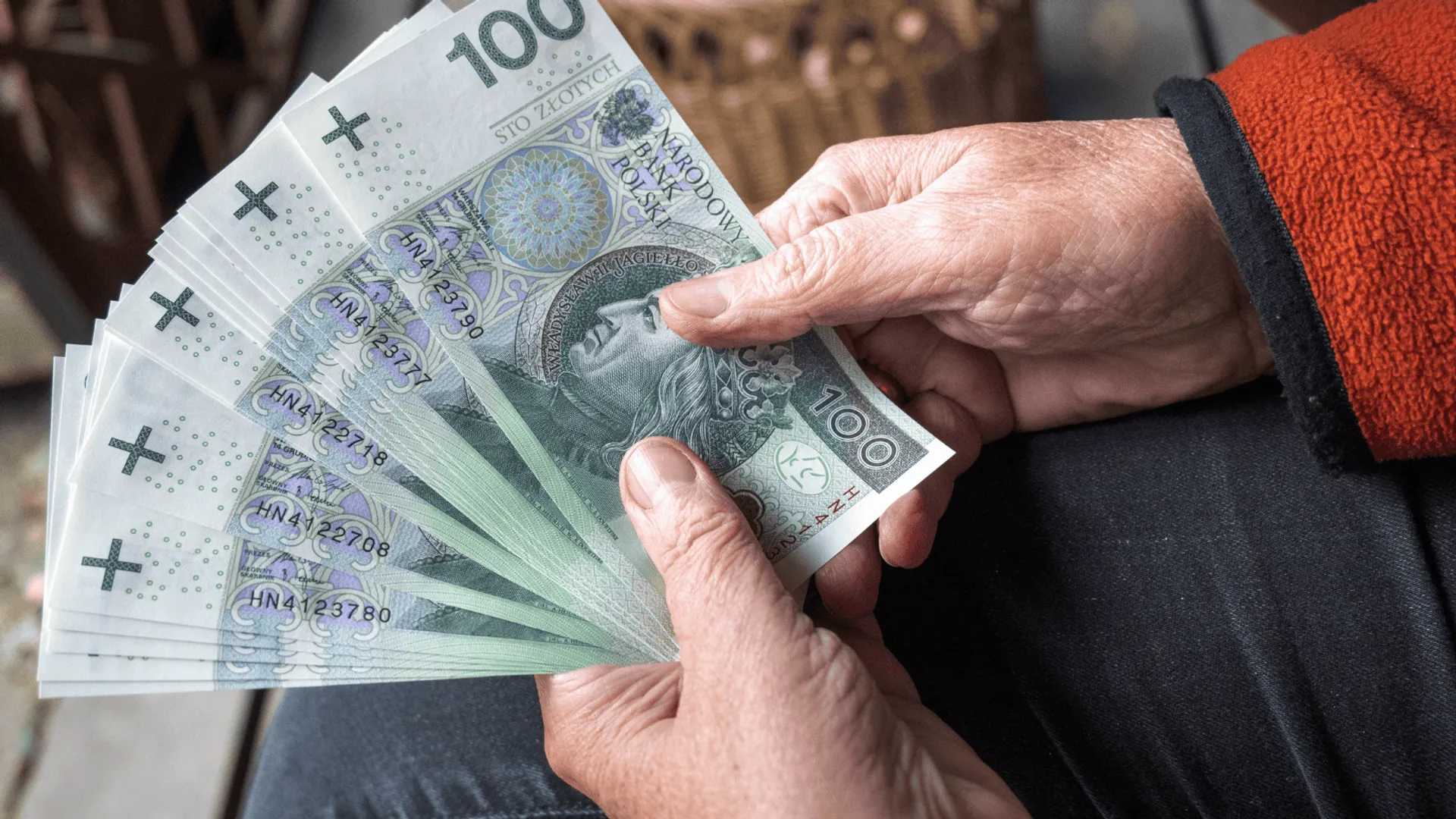 senior trzyma w ręku banknoty