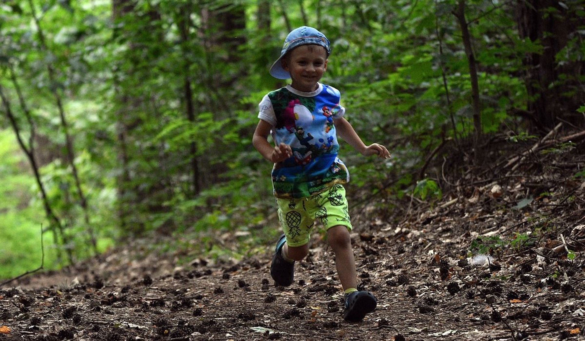 chłopiec biegnący w lesie