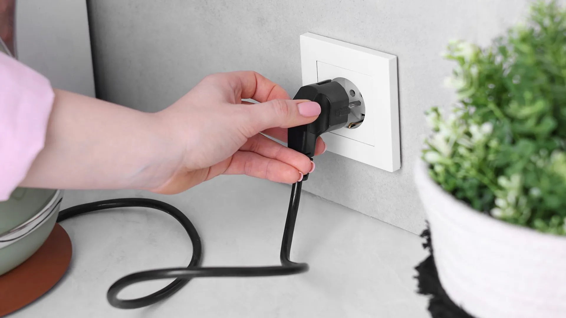 ręka kobieta wyciąga wtyczkę 