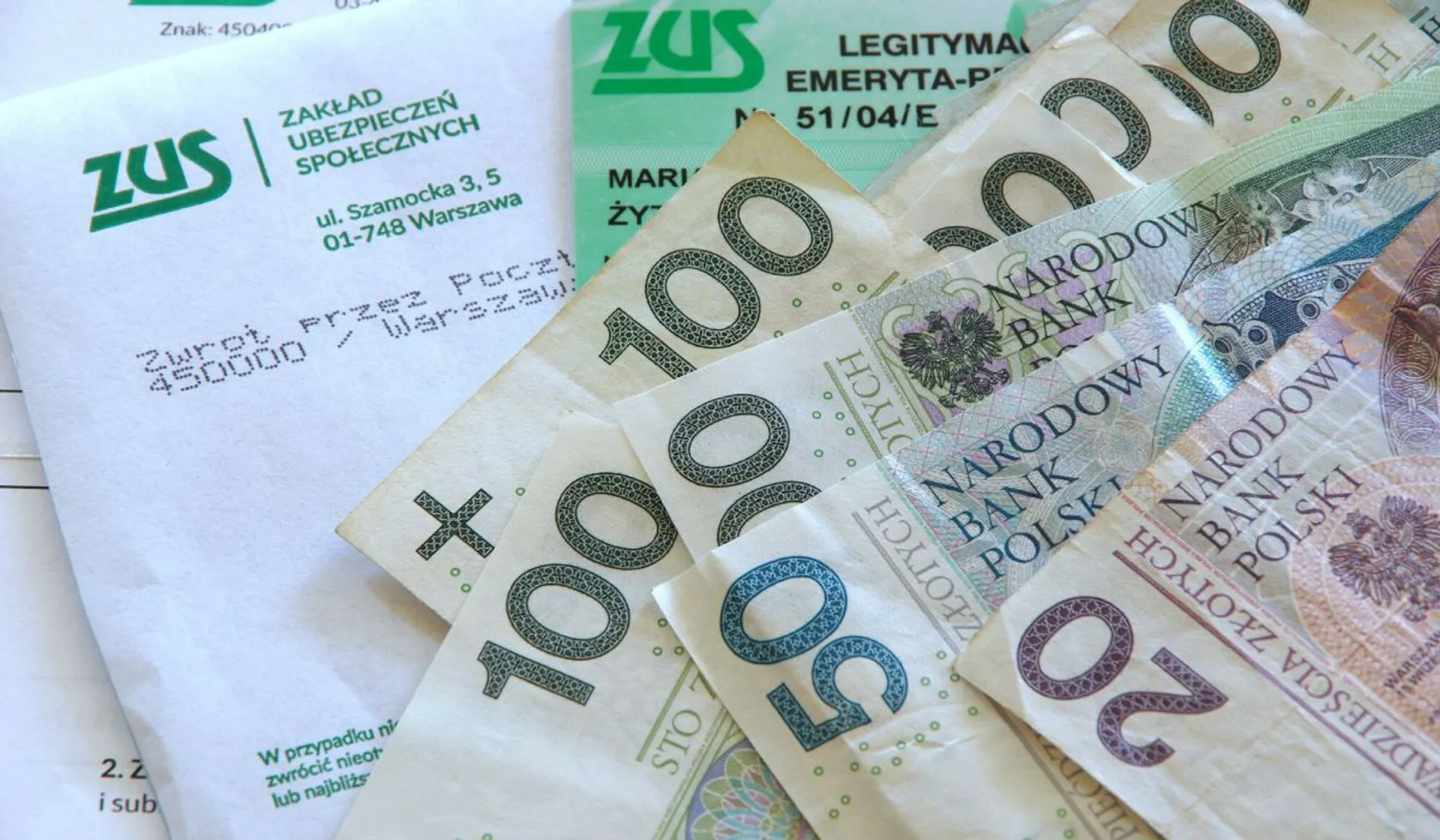 Koperta ZUS, pieniądze, legitymacja emeryta-rencisty