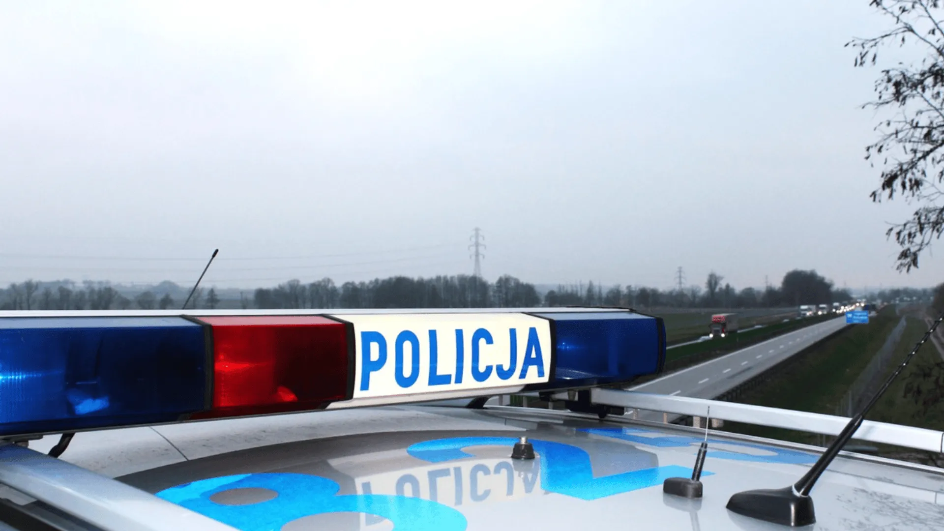 Radiowóz policji na drodze podczas prowadzonych czynności służbowych.