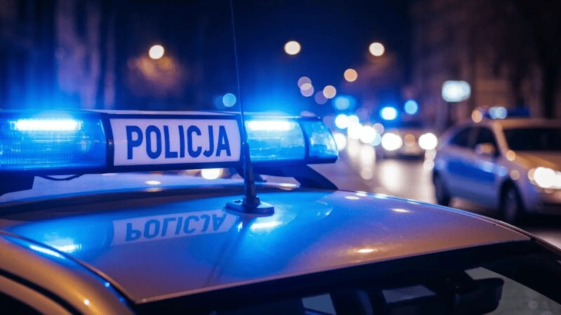 Policyjny radiowóz z włączonymi "kogutami".