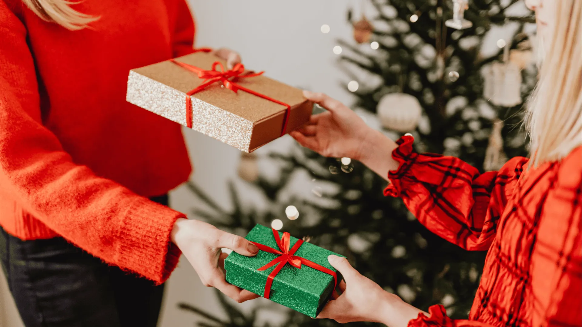 Osoby wymieniające się prezentami podczas świątecznego spotkania.
