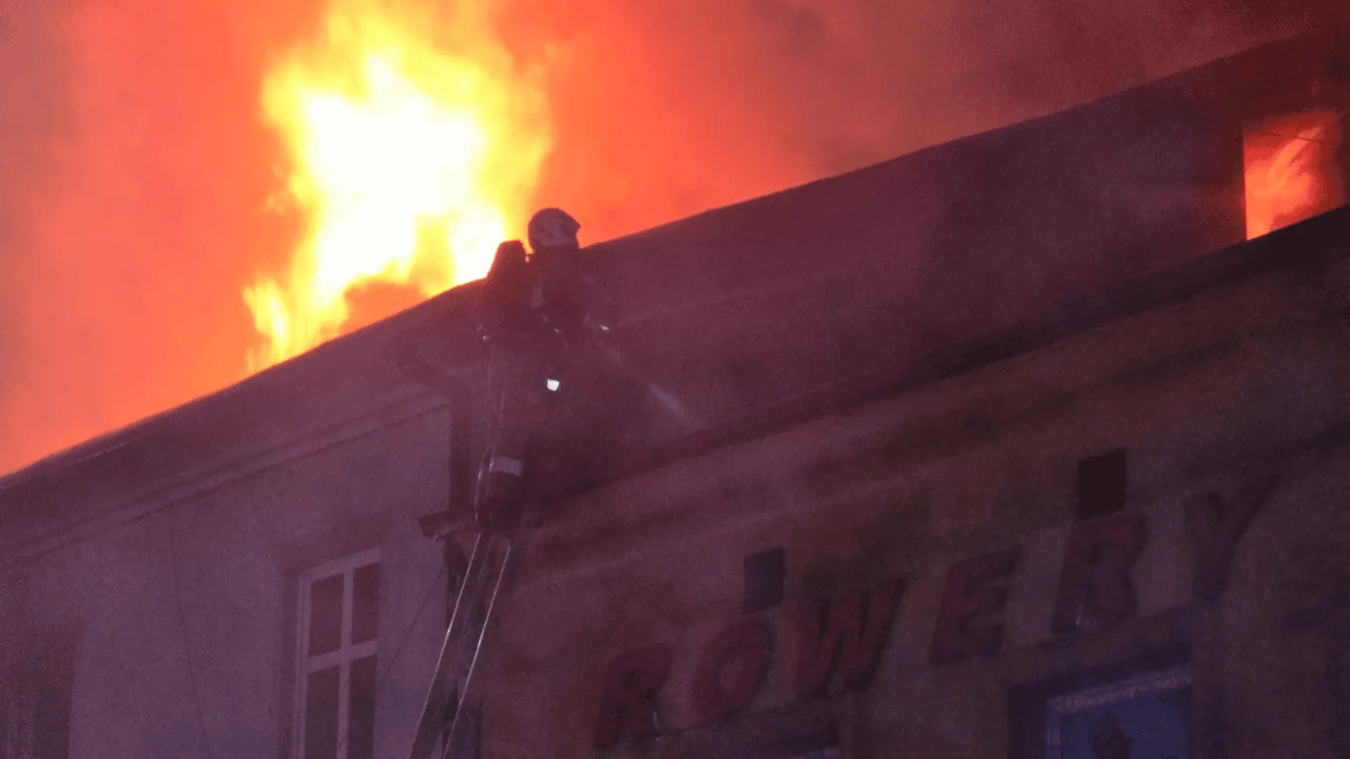 Strażak gaszący ogień w budynku.