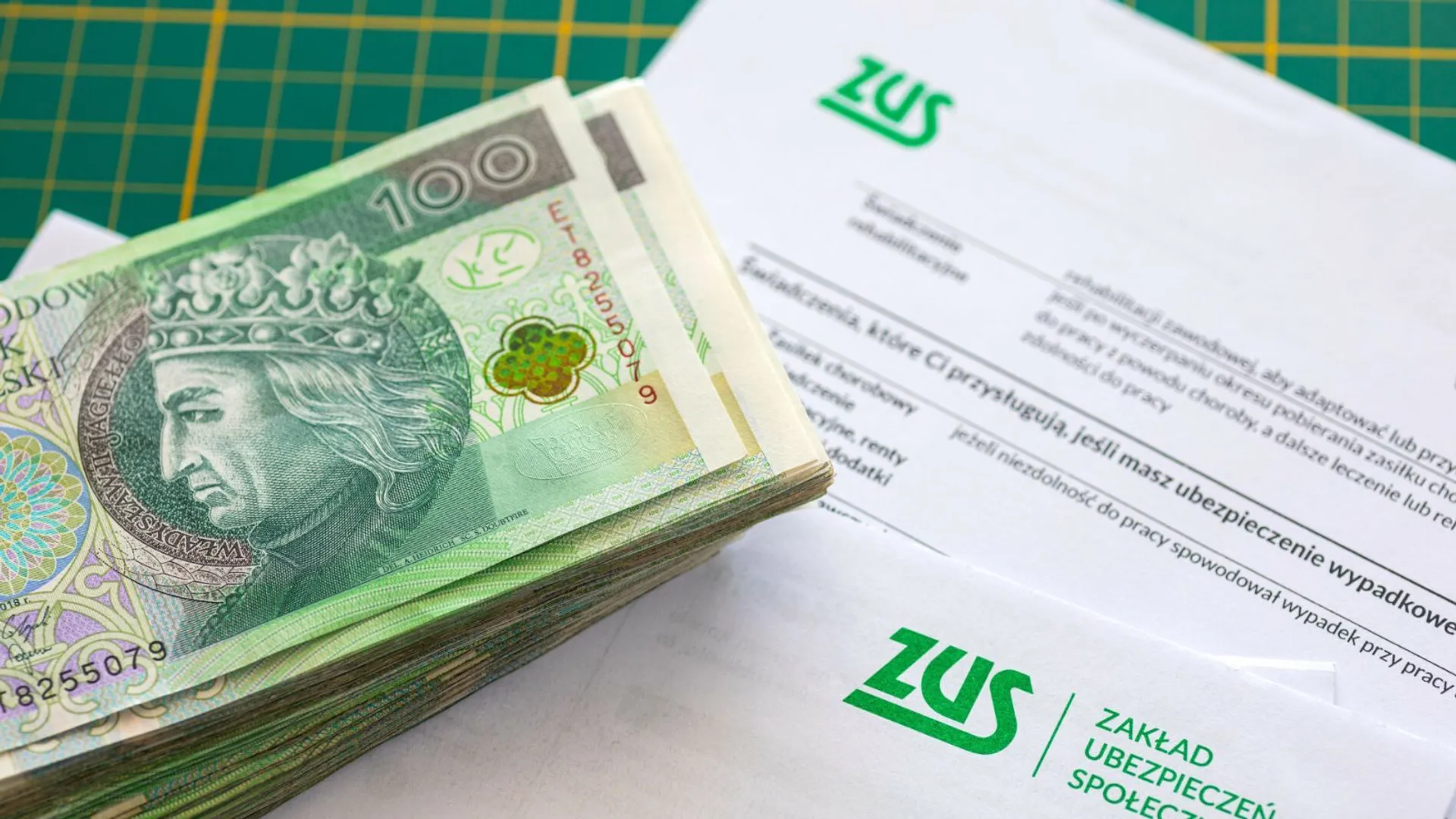 Napis i logo ZUSu z pieniędzmi w tle