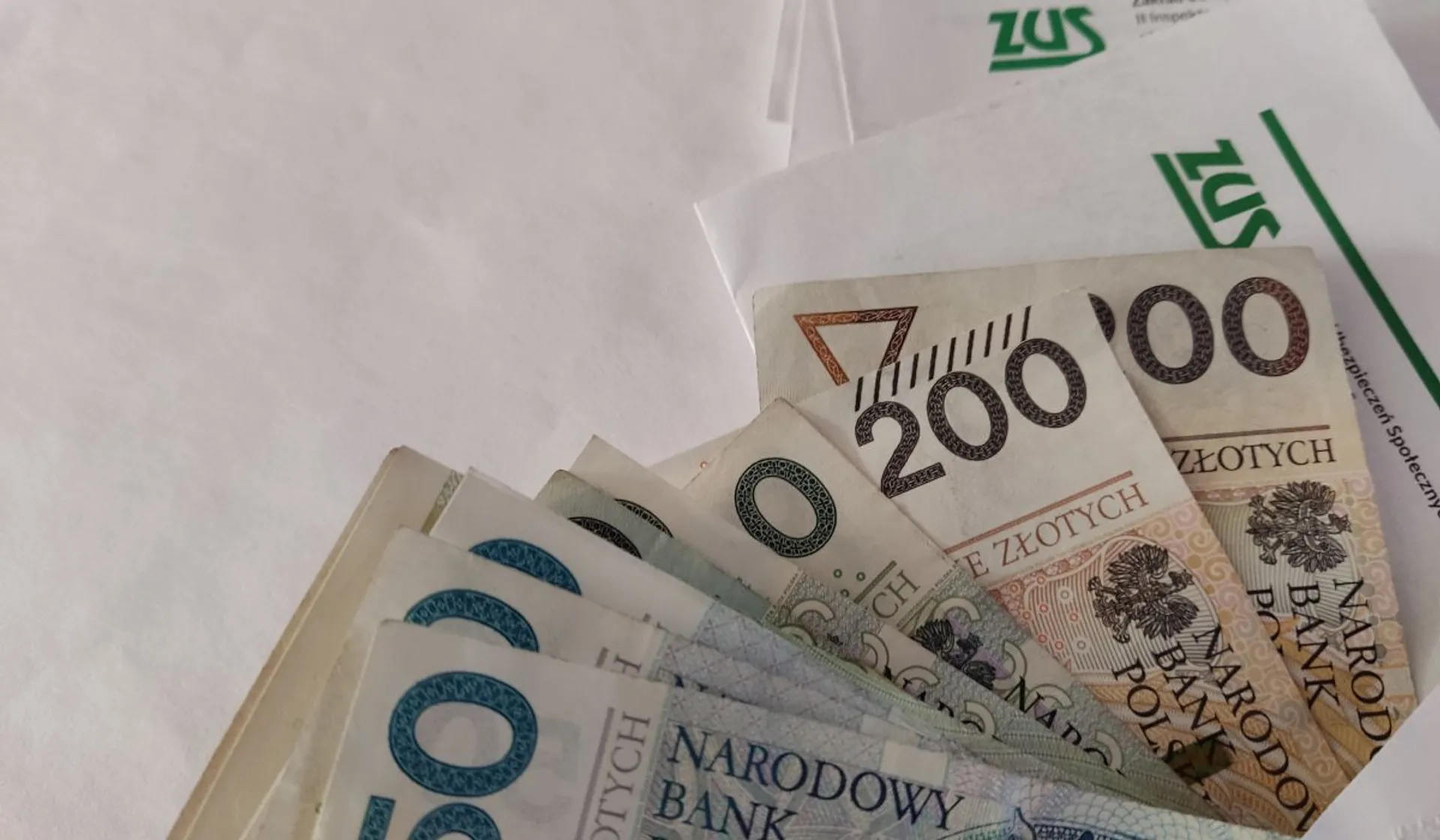 Pieniądze, koperta z logo ZUS-u