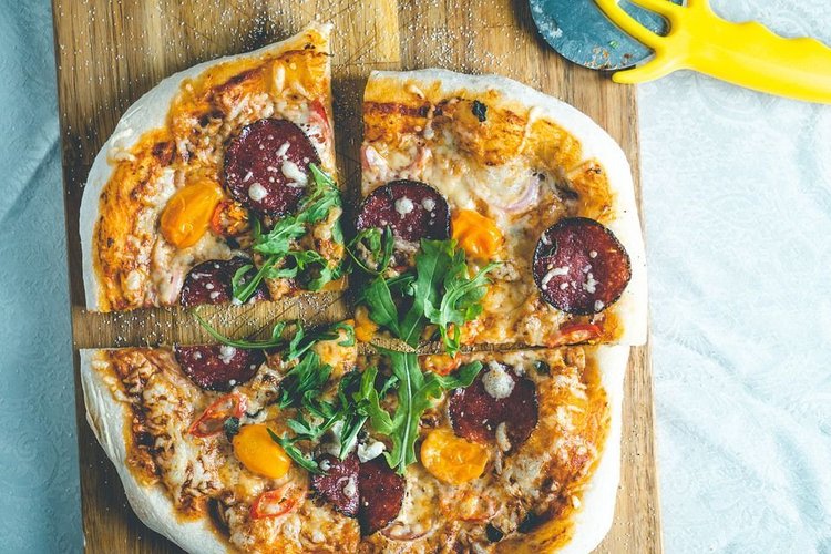 Pizza z mozzarellą, pomidorkami, rukolą i szynką parmeńską
