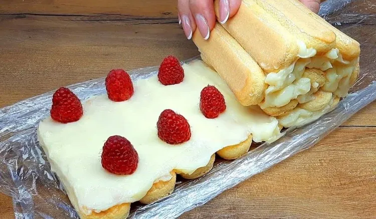 Układam obok siebie biszkopty i zawijam je z kremem i owocami. Moje ciasto bez pieczenia to hit sezonu