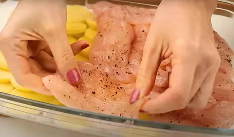 Pokrój ziemniaki i przykryj je piersią z kurczaka. Pomysł na szybki obiad