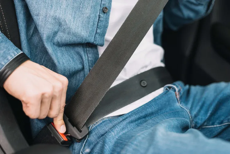 Jaką rolę pełni plastikowy guzik na pasie bezpieczeństwa?