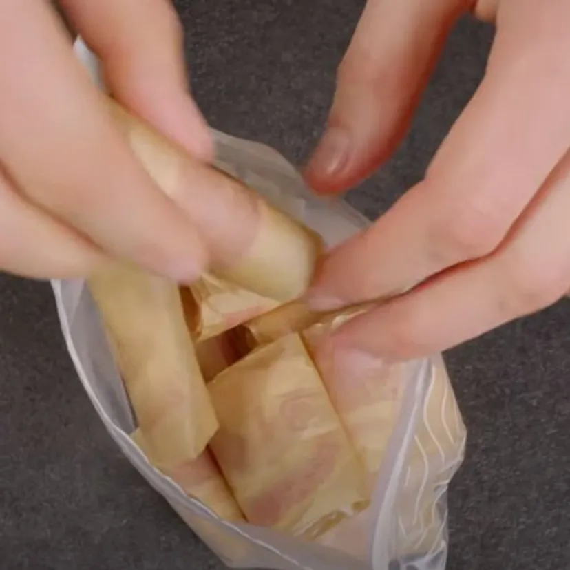 Zawijam boczek w papier do pieczenia i tnę na mniejsze kawałki. Żałuję, że nie znałem tego wcześniej