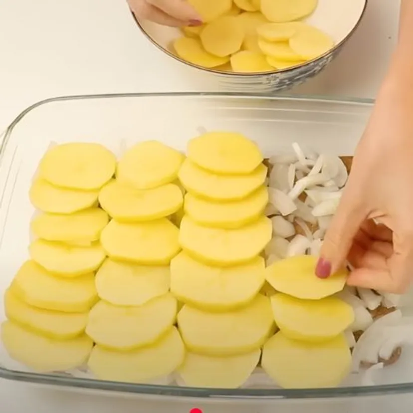 Pokrój ziemniaki i przykryj je piersią z kurczaka. Pomysł na szybki obiad