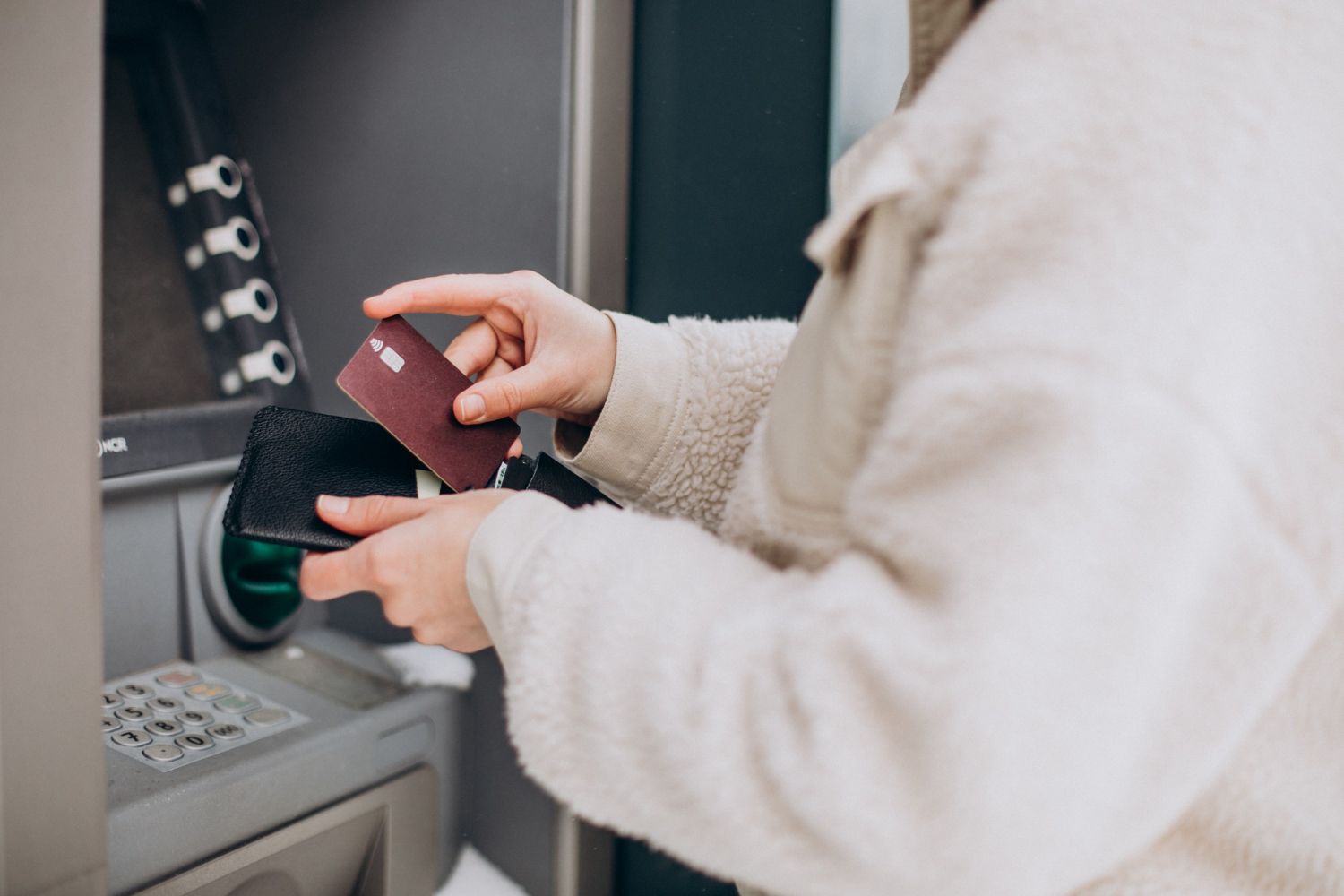 Kobieta wypłacająca pieniądze w bankomacie