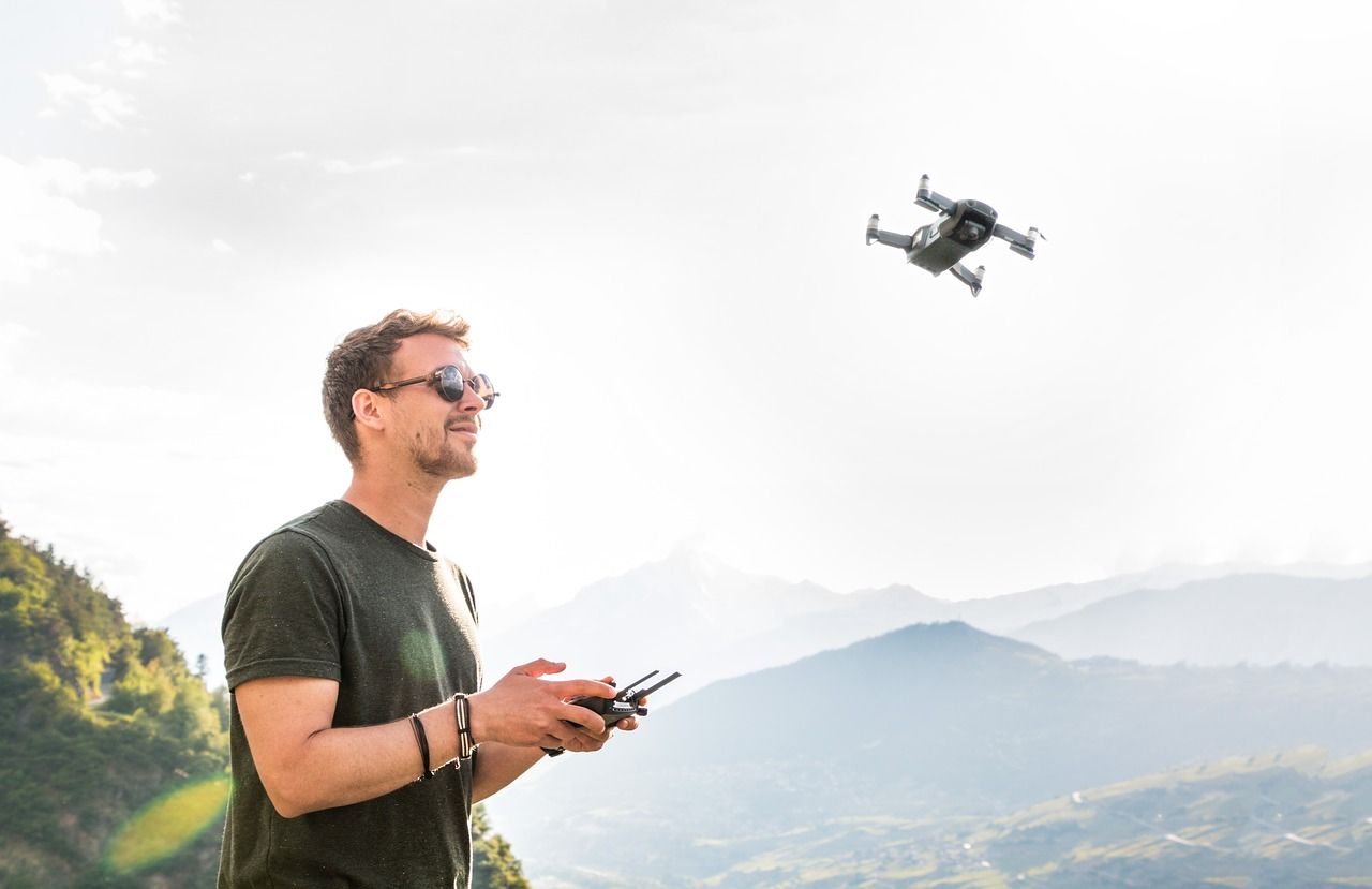 Mężczyzna sterujący dronem w górach.