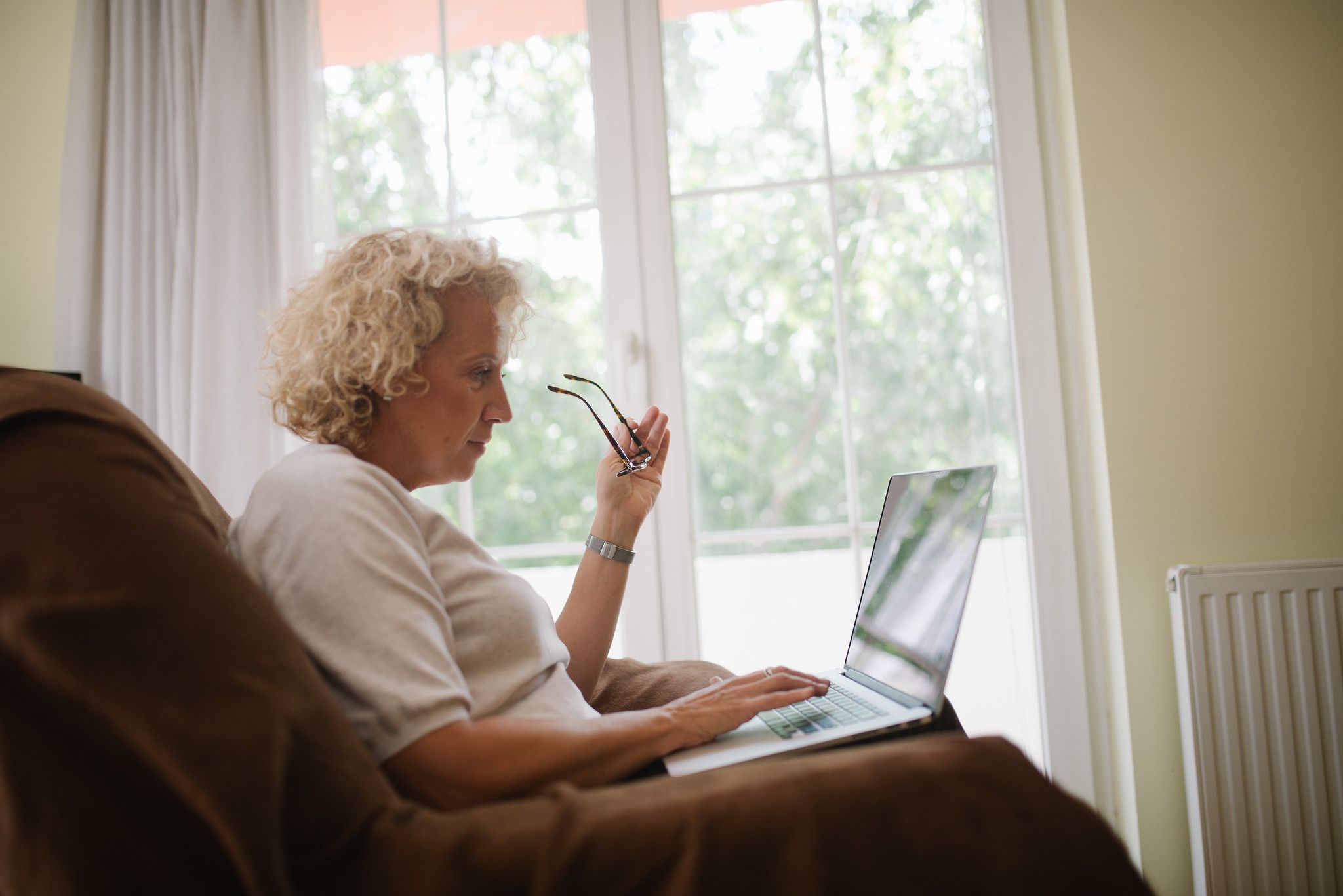 Starsza kobieta trzymająca laptopa