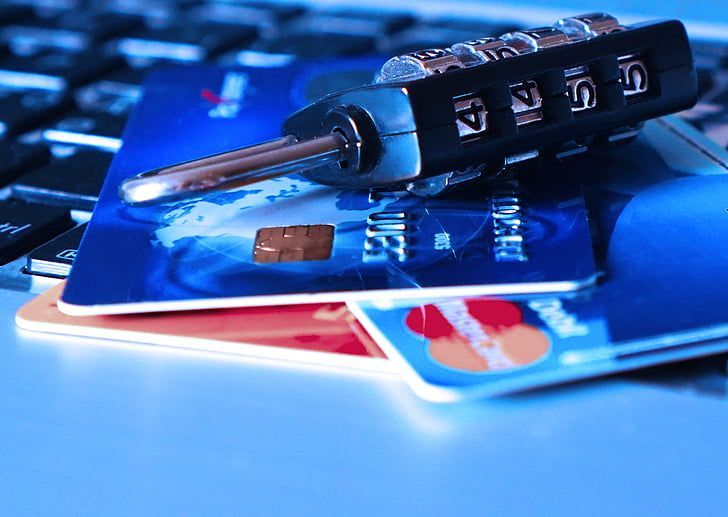 Karty kredytowe z kłódką leżące na klawiaturze laptopa.