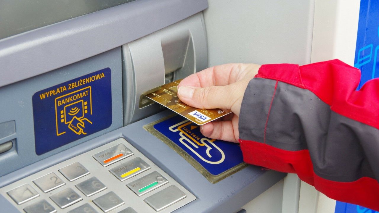 Wypłata pieniędzy z bankomatu, złota karta kredytowa