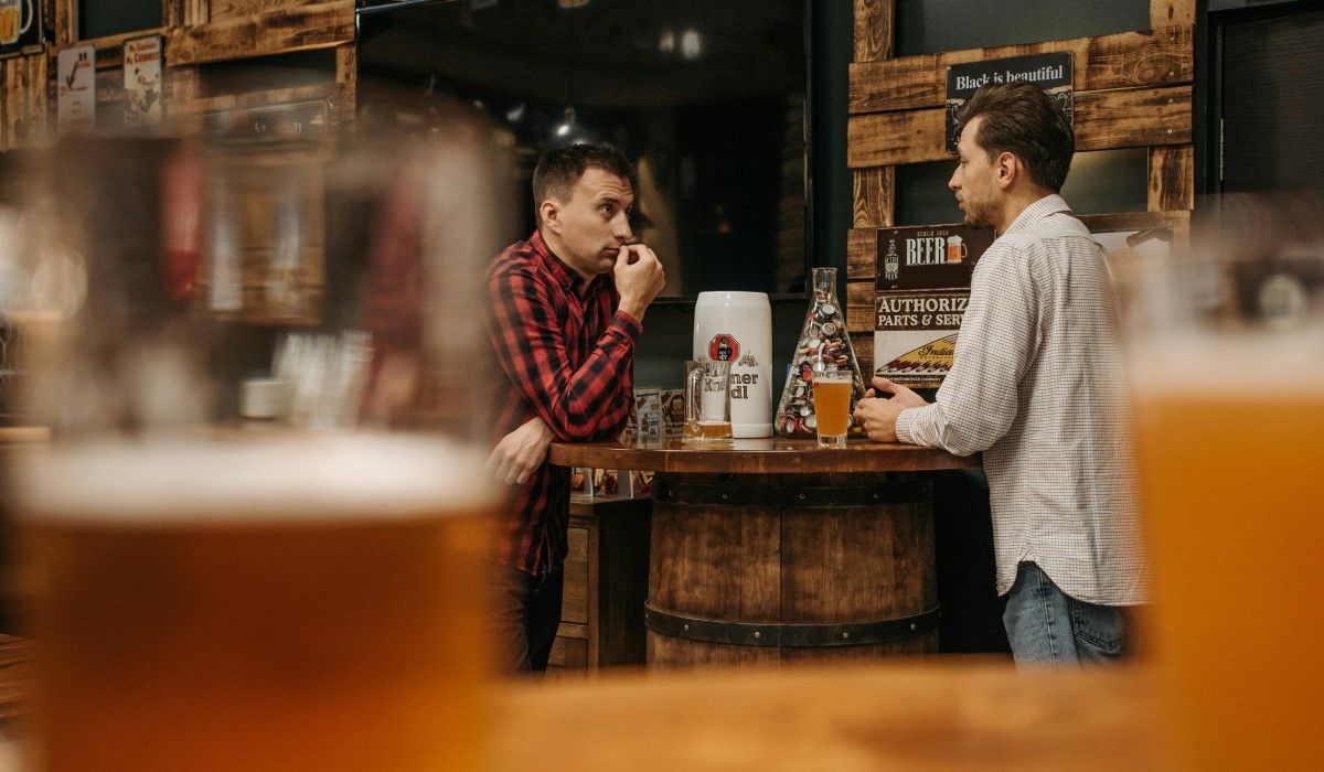 Mężczyźni w barze piją piwo
