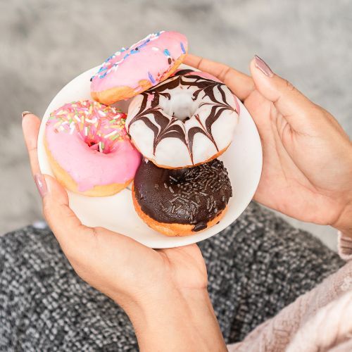 pączki na talerzyku w rękach kobiety Fot. doucefleur/Canva.jpg