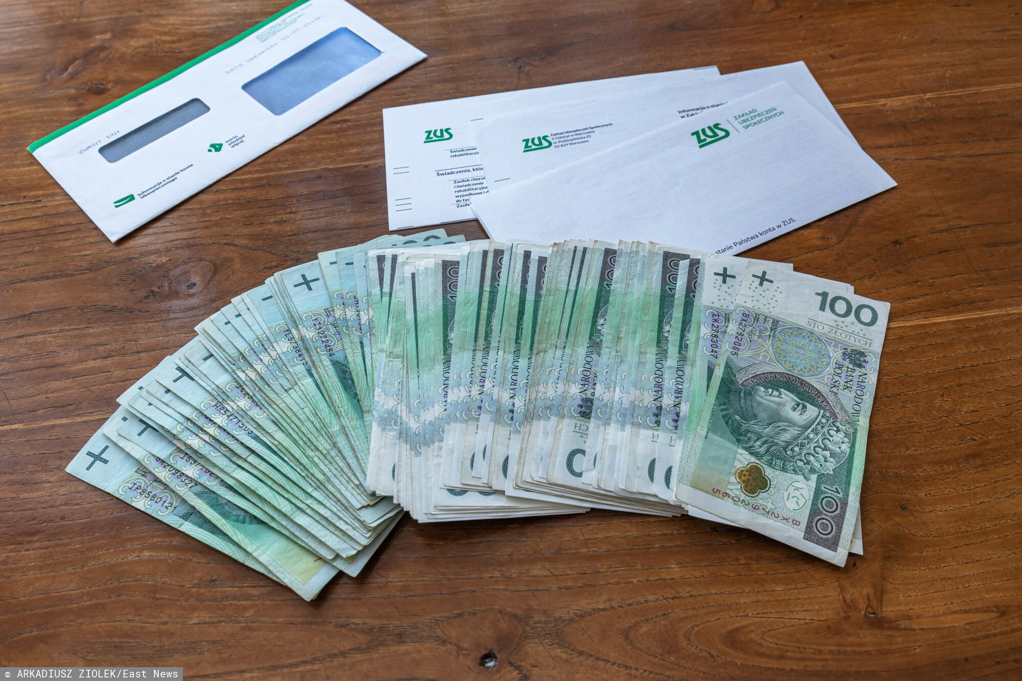 Pieniądze, banknoty 100 zł, koperta od ZUS-u