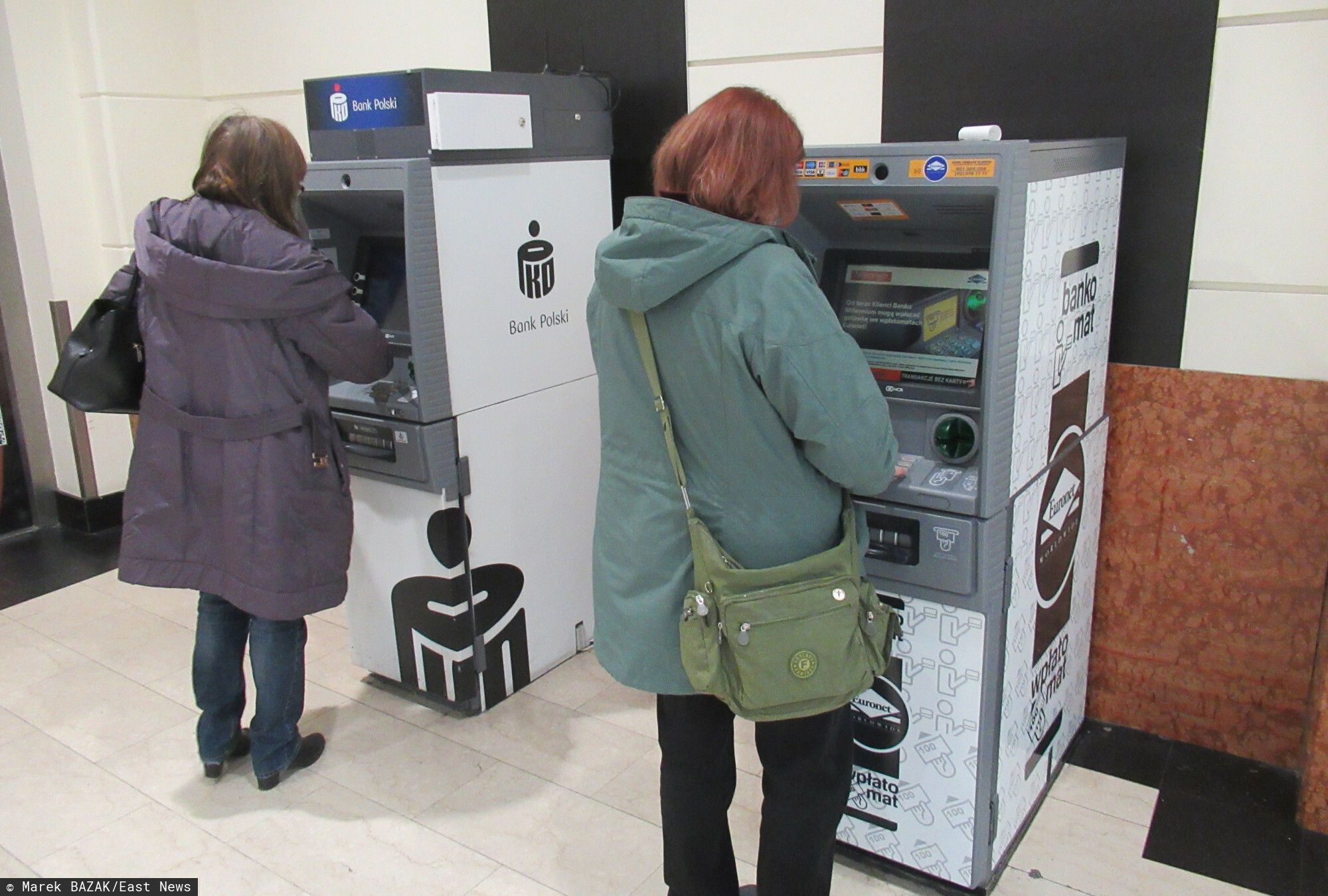 Kobiety stojące przy bankomatach