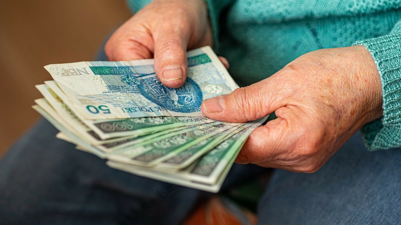 Emerytka trzyma w rękach pieniądze