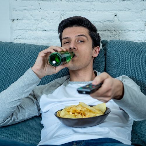 chłpak z piwem, czupsami i pilotem TV Fot. SB Arts Media/Getty Images.jpg