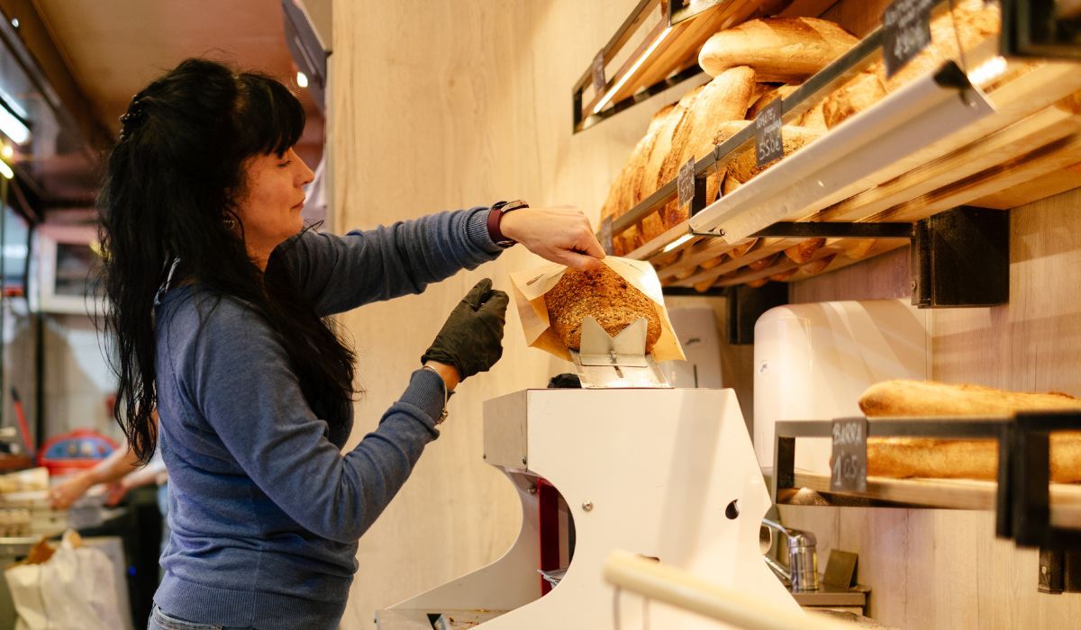 Kobieta w sklepie kroi chleb