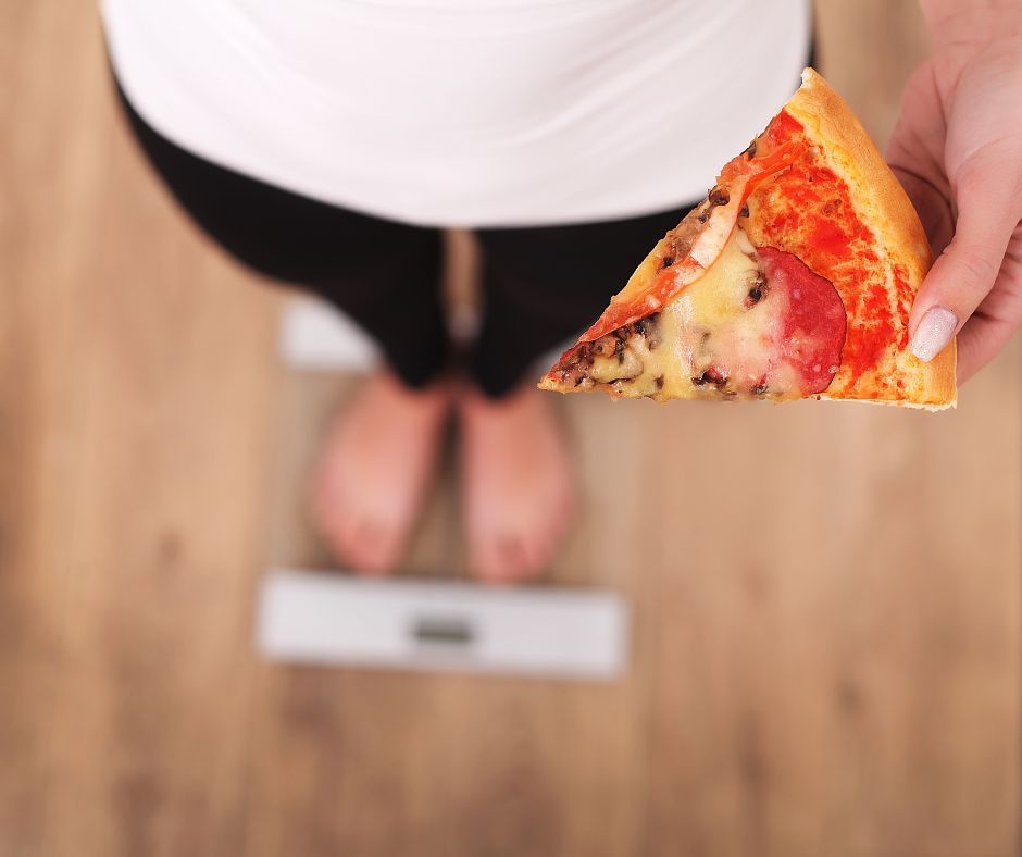 Kobieta z pizzą stoi na wadze