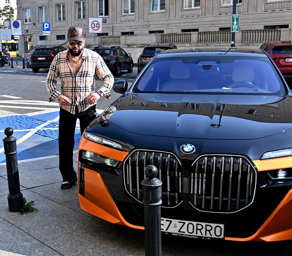 Krzysztof Rutkowski pozuje do zdjęć przy swoim samochodzie