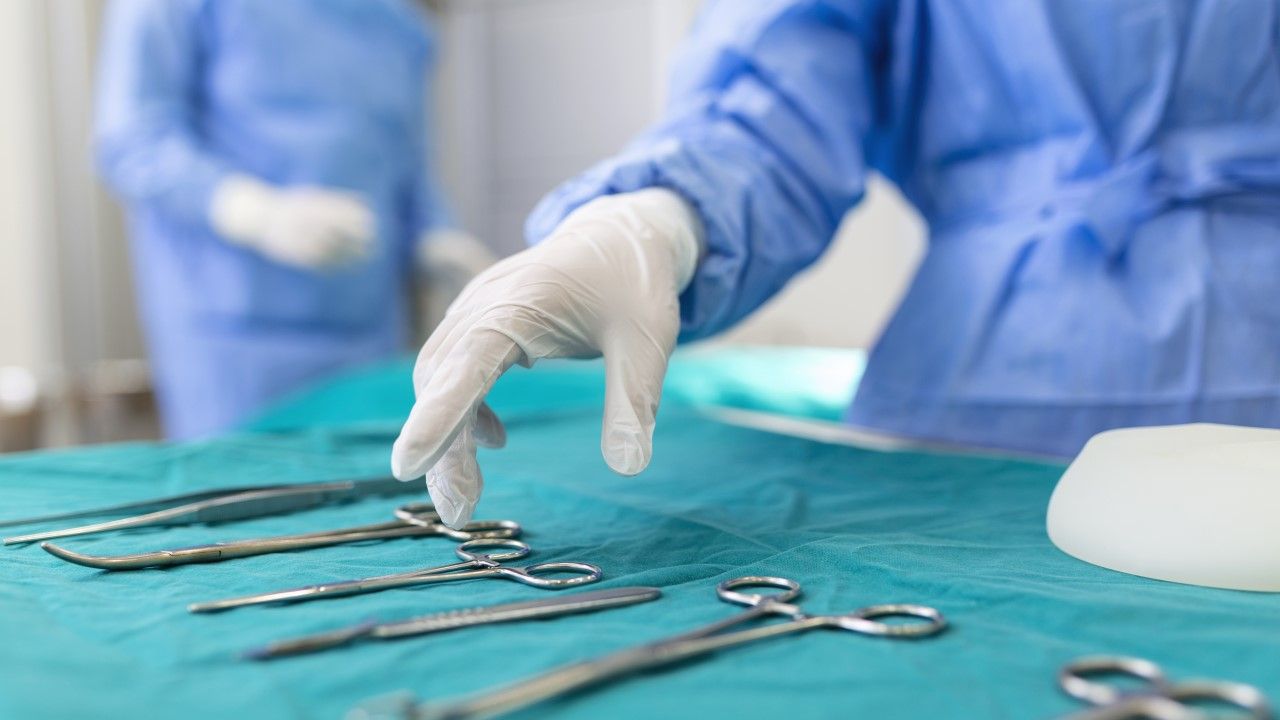 Chirurg sięga po narzędzie chirurgiczne