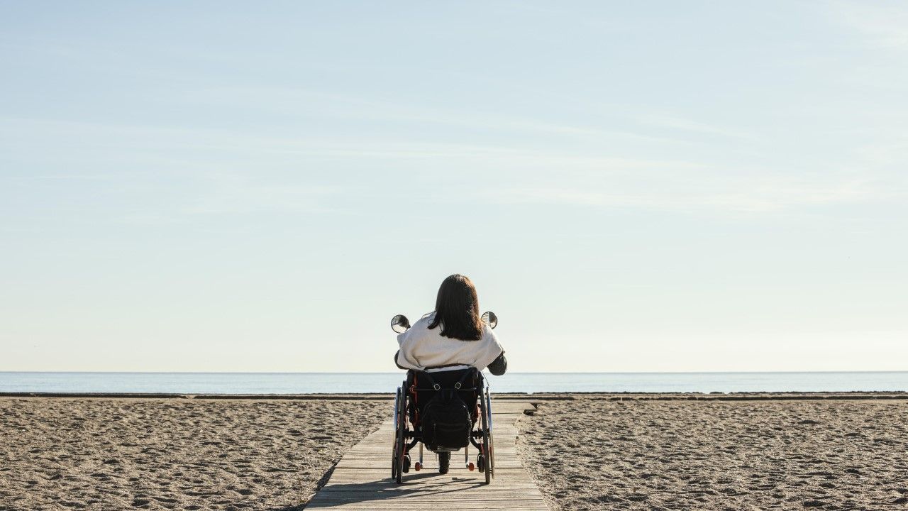 Kobieta na wózku inwalidzkim na plaży