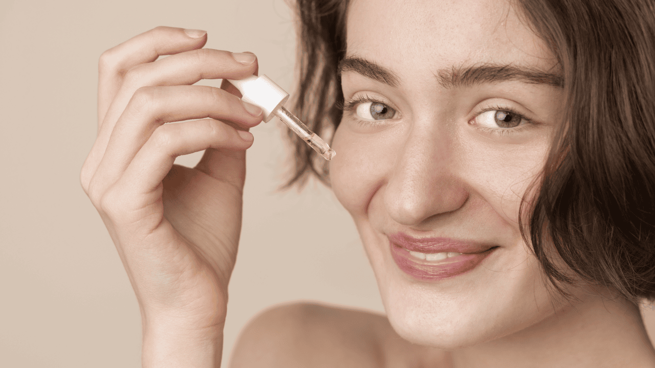 Kobieta nakłada na twarz serum przeciwzmarszczkowe