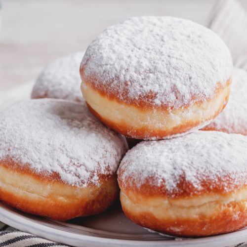 Trzy pączki posypane cukrem pudrem