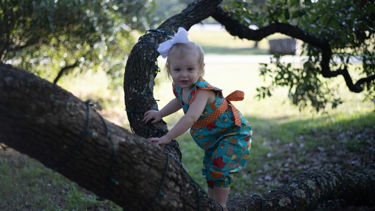 dziewczynka wspina się na drzewo