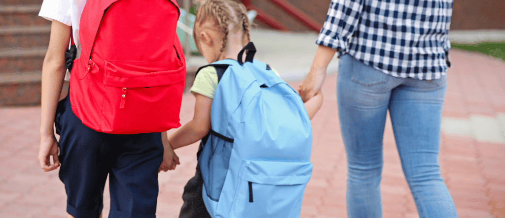 Dzieci idą z mamą do szkoły