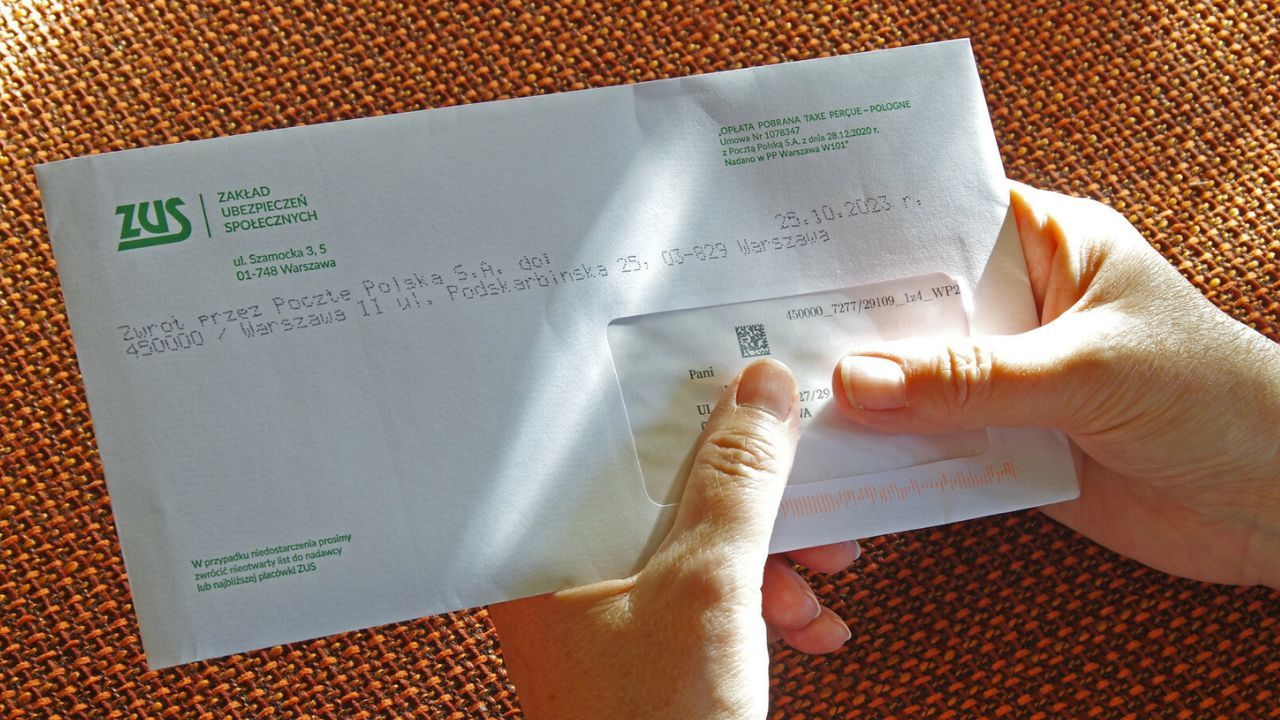 kobieta trzyma w ręku kopertę z pismem z ZUS-u