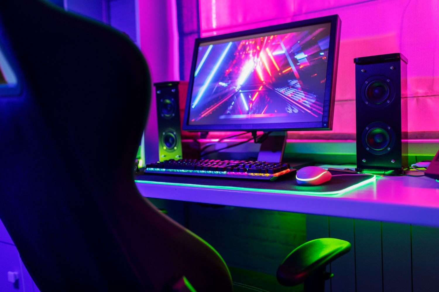 krzesło i komputer dla graczy z wielokolorowymi neonami