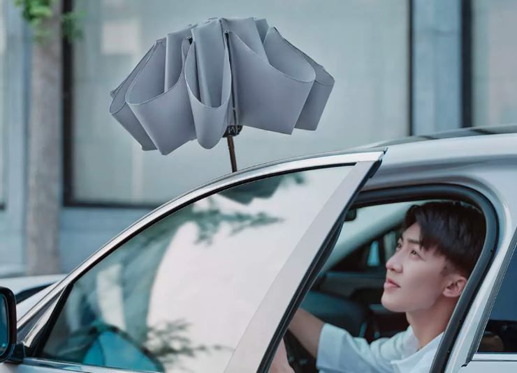 Parasol Xiaomi złożony odwrotnie. Mężczyzna wysiadający z samochodu.