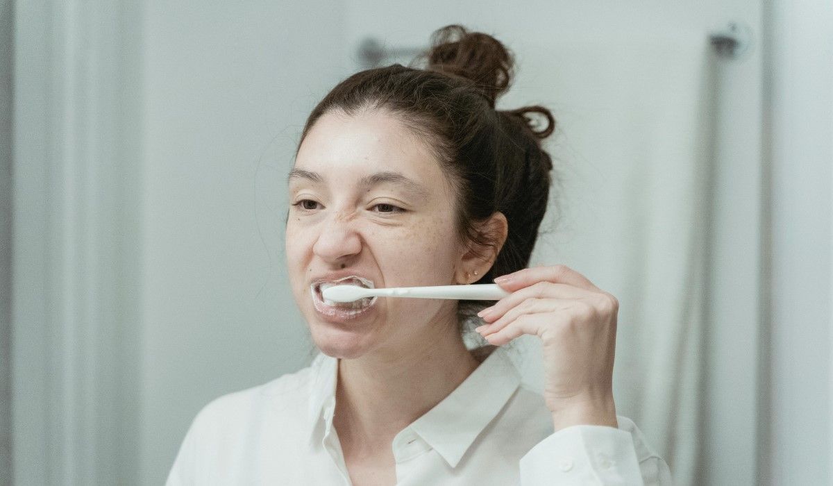 Niezadowolona kobieta myje zęby w łazience