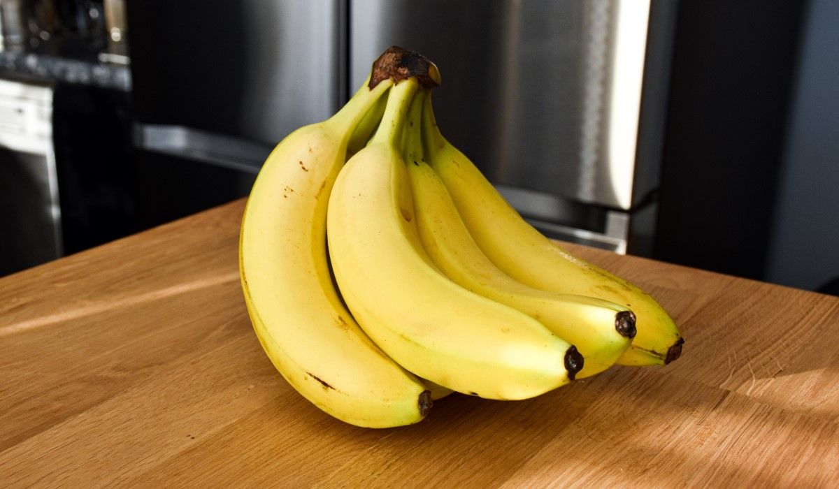 Pęczek zamkniętych bananów w kuchni na blacie