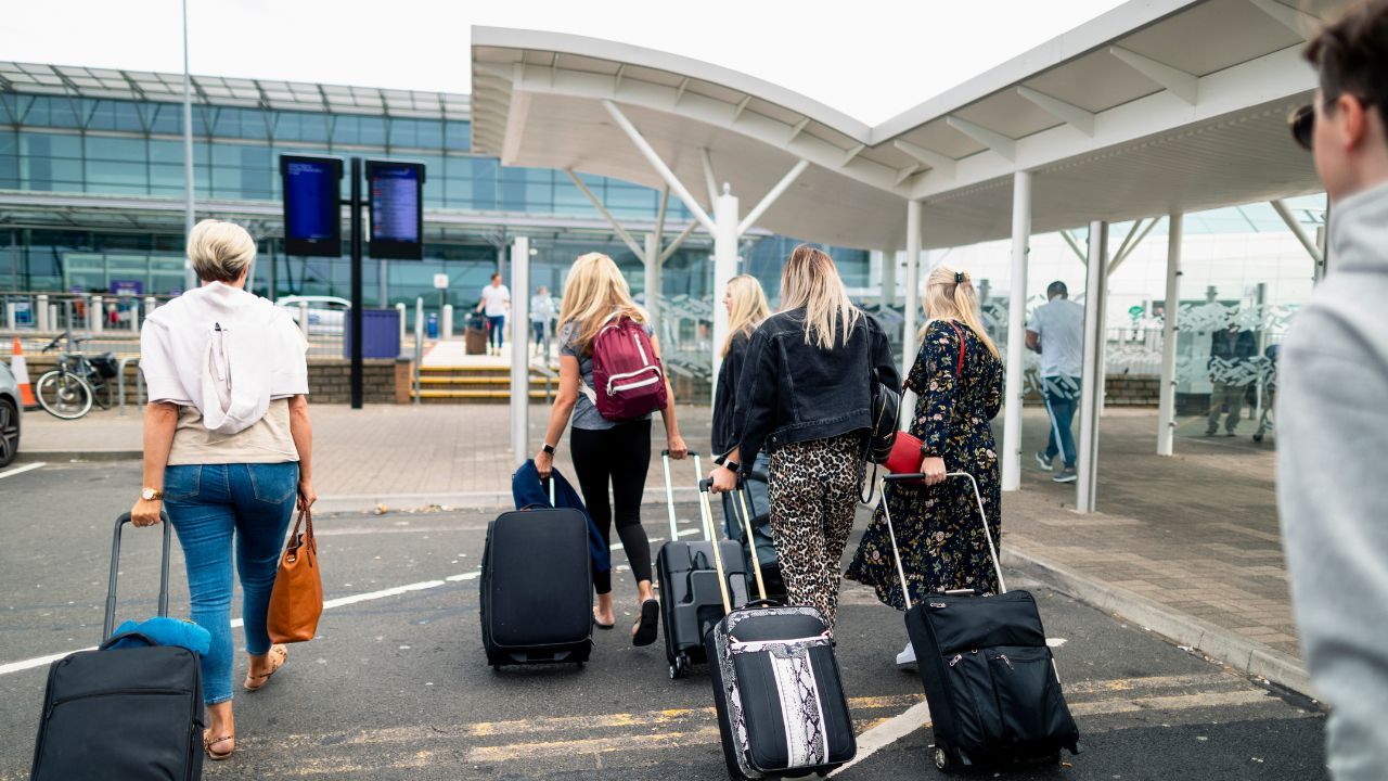 turyści z bagażami na lotnisku