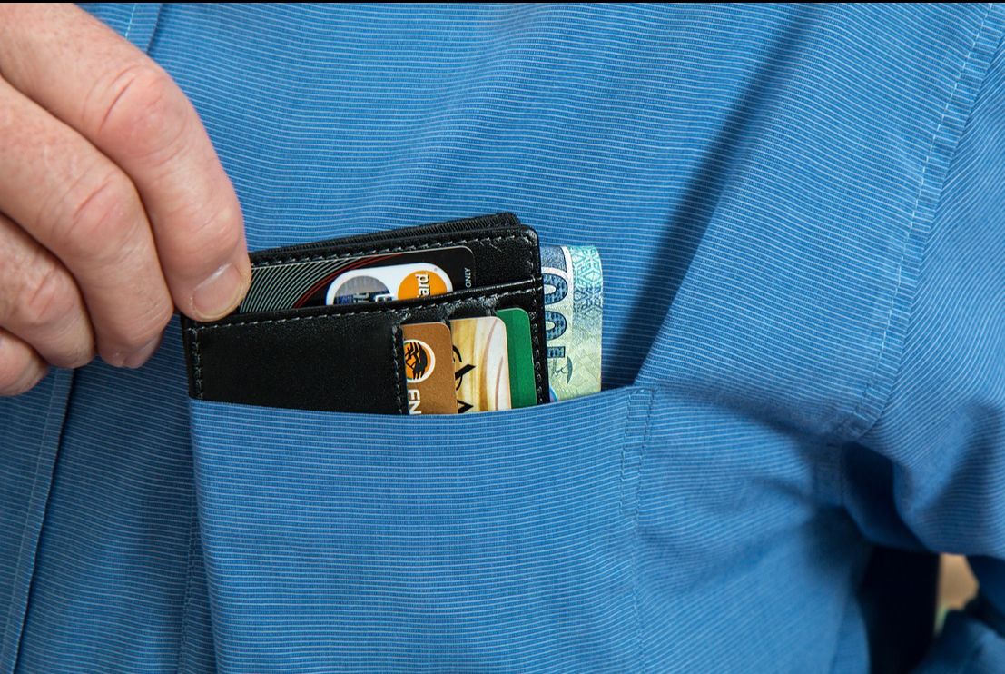 Portfel z pieniędzmi i kartami płatniczymi w kieszonce koszuli